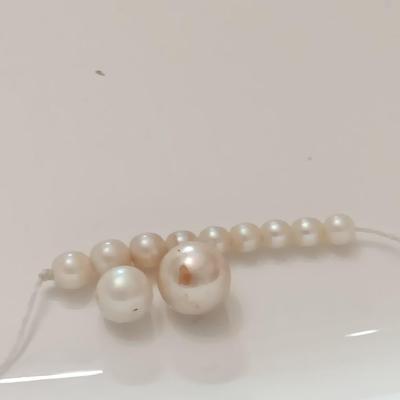 two larger freshwater pearls some smaller on a string