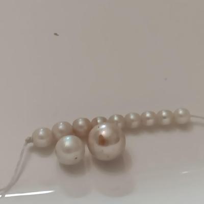 two larger freshwater pearls some smaller on a string
