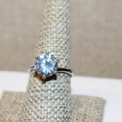 Size 8 Marked .925 Highrise 6 Prong Round Clear Stone Ring on an Overlap Silver Tone Band (4.8g)