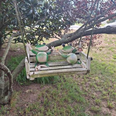 Frogs on a bench swing