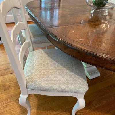 Oval wood dining table and six freshly upholstered chairs