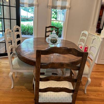 Oval wood dining table and six freshly upholstered chairs