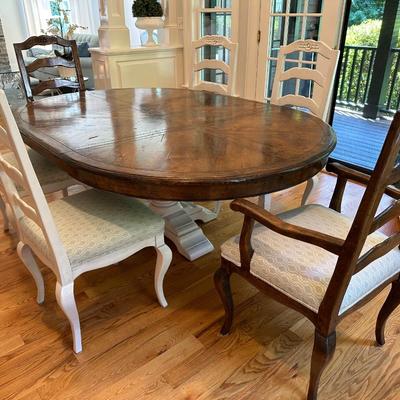 Oval wood dining table and six freshly upholstered chairs