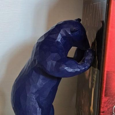 Blue Bear that Looks like he is Holding Up Books, Objects, Ect.