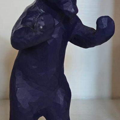 Blue Bear that Looks like he is Holding Up Books, Objects, Ect.