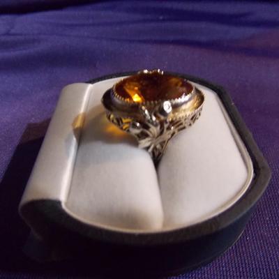 An antique sterling silver ring w/ a filigree base and a oval glass set in the ring.