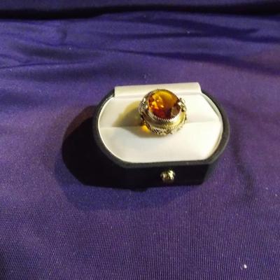 An antique sterling silver ring w/ a filigree base and a oval glass set in the ring.
