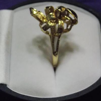 A cocktail ring in 14kt gold with a ribbon effect at the head.