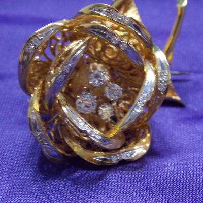 A brooch/pin in 18kt gold weighting approx of 37 grams. Total weight of Diamonds is .83 carats.