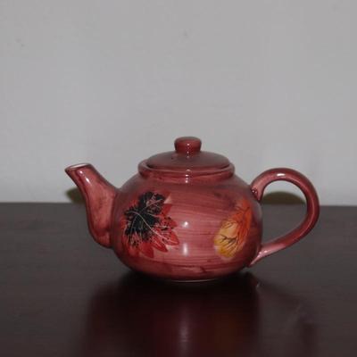 Red teapot with leaves