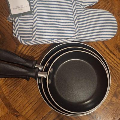 3 skillets and a pot holder set
