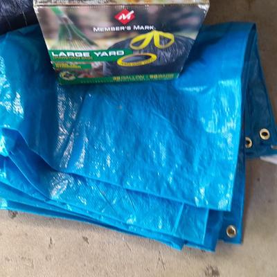 Trashcan with tarp and trash bags