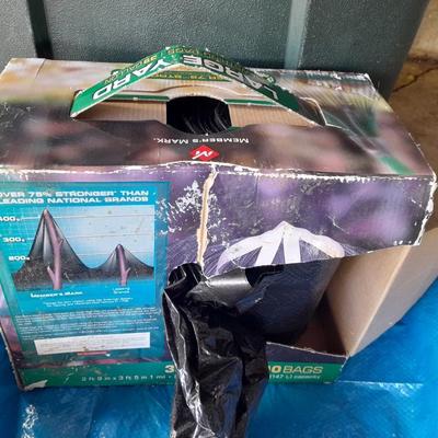 Trashcan with tarp and trash bags