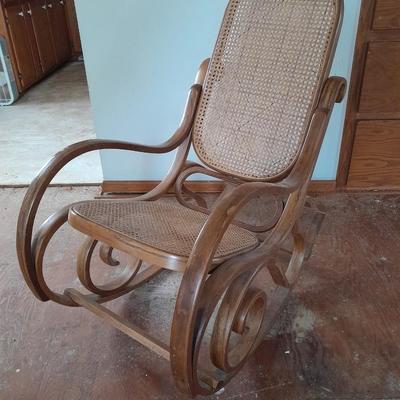 Wood framed wicker seat rocking chair with tall black lamp