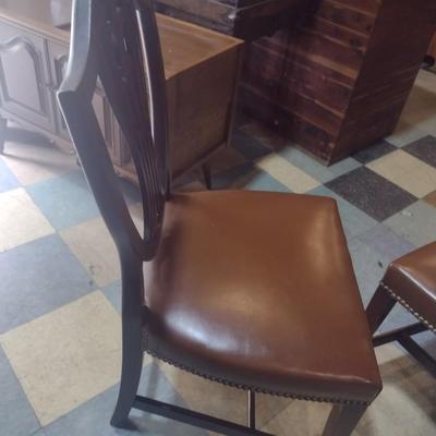Set of four wood framed chairs with brass tack accents