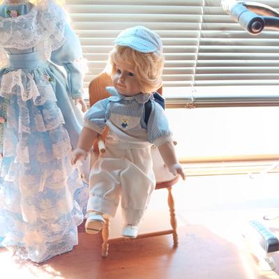 2 SWEET PORCELAIN DOLLS AND A WOODEN DOLL CHAIR