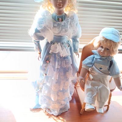 2 SWEET PORCELAIN DOLLS AND A WOODEN DOLL CHAIR