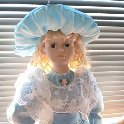 2 SWEET PORCELAIN DOLLS AND A WOODEN DOLL CHAIR