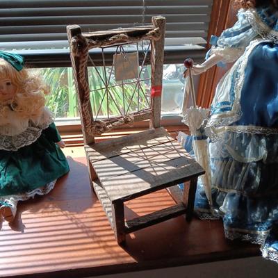 2 PRETTY PORCELAIN DOLLS AND A WOODEN DOLL CHAIR