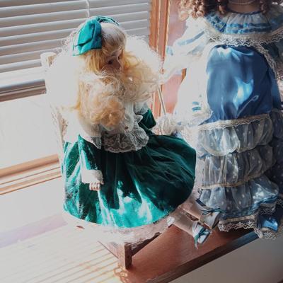2 PRETTY PORCELAIN DOLLS AND A WOODEN DOLL CHAIR