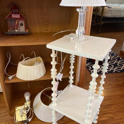 Bookshelf, white side table, lucite lamp, books