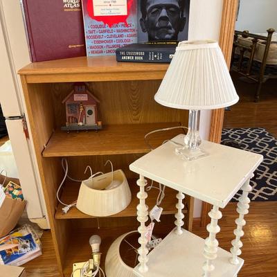 Bookshelf, white side table, lucite lamp, books