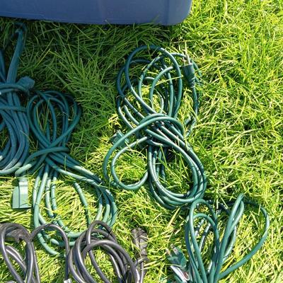 A VARIETY OF OUTDOOR EXTENSION CORDS AND A STORAGE TOTE