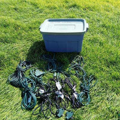 A VARIETY OF OUTDOOR EXTENSION CORDS AND A STORAGE TOTE