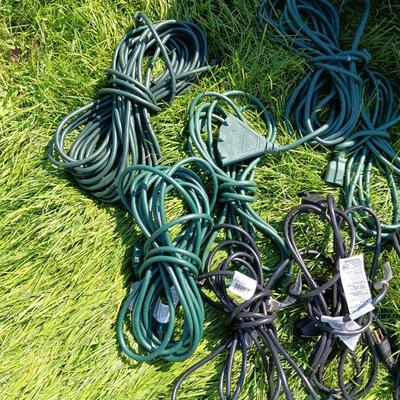 A VARIETY OF OUTDOOR EXTENSION CORDS AND A STORAGE TOTE