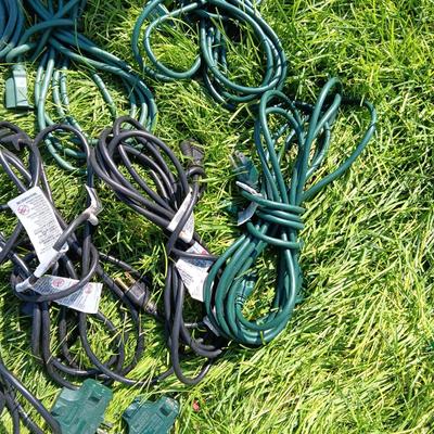 A VARIETY OF OUTDOOR EXTENSION CORDS AND A STORAGE TOTE