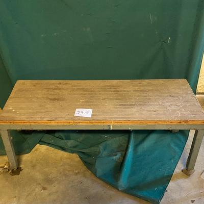 Metal Table with Wheels on one end.