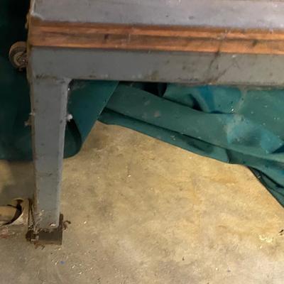 Metal Table with Wheels on one end.