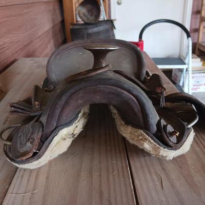 A SMALL CHILD'S SADDLE AND A STAINED GLASS STEER