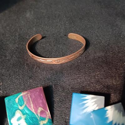 A COLLECTION OF PIERCED EARRINGS AND A COPPER BRACELET