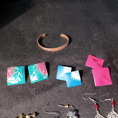 A COLLECTION OF PIERCED EARRINGS AND A COPPER BRACELET