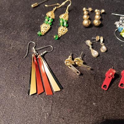 A COLLECTION OF PIERCED EARRINGS AND A COPPER BRACELET