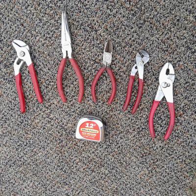 Red handled pliers and a tape measure