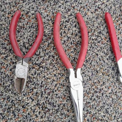 Red handled pliers and a tape measure