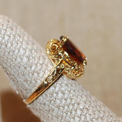 Size 7½ Oval Brown & Amber Stone Ring on a 4 Prong Nest Setting with a Gold Tone Band (4.2g)