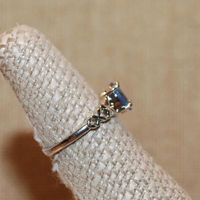 Size 7 Oval Blue 4 Prong Main Stone Ring with "Looped" Side Accents on a Silver Tone Band (2.2g)
