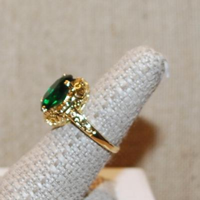 Size 7¼ Oval Deep Green Stone Ring on a 4 Prong Nest Setting with a Gold Tone Band (4.4g)