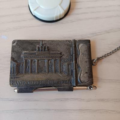 ANTIQUE GERMAN EMBOSSED METAL NOTEPAD WITH PEN AND SMALL PLASTIC POWDER COMPACT