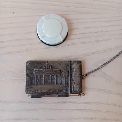 ANTIQUE GERMAN EMBOSSED METAL NOTEPAD WITH PEN AND SMALL PLASTIC POWDER COMPACT
