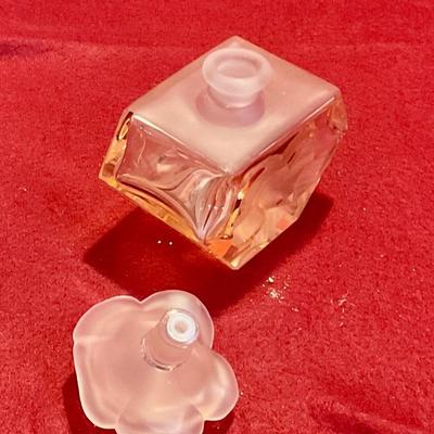 Pink perfume bottle with rose stopper and embossed flower on bottle
