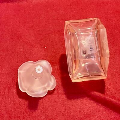 Pink perfume bottle with rose stopper and embossed flower on bottle