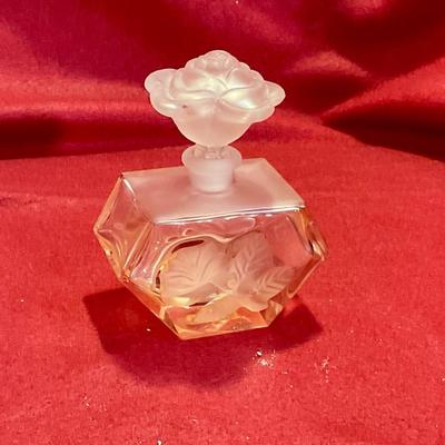 Pink perfume bottle with rose stopper and embossed flower on bottle