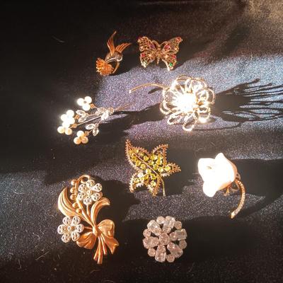 A COLLECTION OF PINS AND BROOCHES