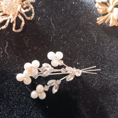 A COLLECTION OF PINS AND BROOCHES