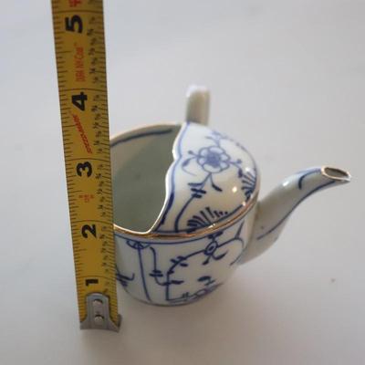 4 small Asian trinket plates with a small tea pot