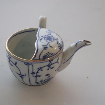 4 small Asian trinket plates with a small tea pot